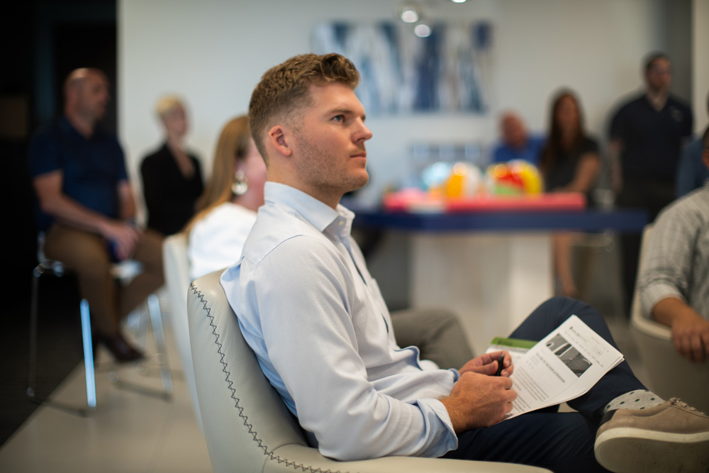 Man sits with a paper in hand listening